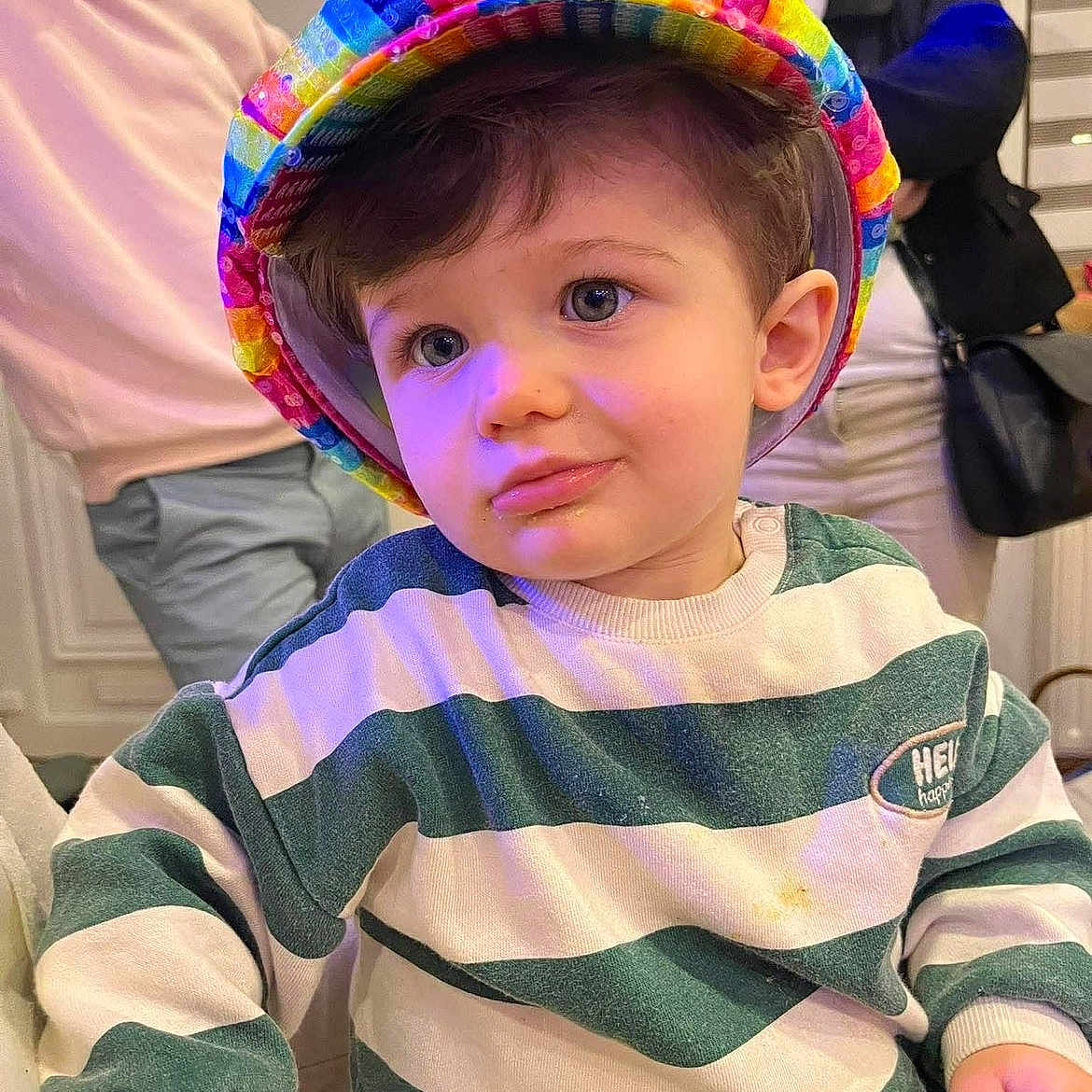 Jules a rejoint le concours — aidez-le/la à gagner de superbes lots ! toddler, child, hat, rainbow, striped_sweater, indoor, people, adult, portrait, curious, smile, family, casual_clothing, person, young_child, colorful, cute, fashion, background, warm_lighting