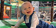 Eliott participe au concours pour gagner de l'argent avec cette photo : baby, child, climbing_structure, crawling, denim_overalls, eyes, face, floor, hand, happy, head, indoor, mouth, netting, padded_mat, person, play_area, playground, smiling, toy_indoor