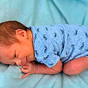 Devin is registered to the contest to win money with this photo: baby, newborn, infant, blue_onesie, bicycle_prints, blanket, sleeping, cute, small, child, face, skin, head, hands, legs, lying_down, soft_texture, cozy, peaceful, portrait