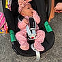 Emilia is registered to the contest to win money with this photo: baby, baby_accessory, black_car_seat, car_seat, child, clothing, cute, hand, infant, newborn, outdoor, pavement, people, pink_bow, pink_onesie, portrait, safety, seat_belt, sucking_fingers, toddler