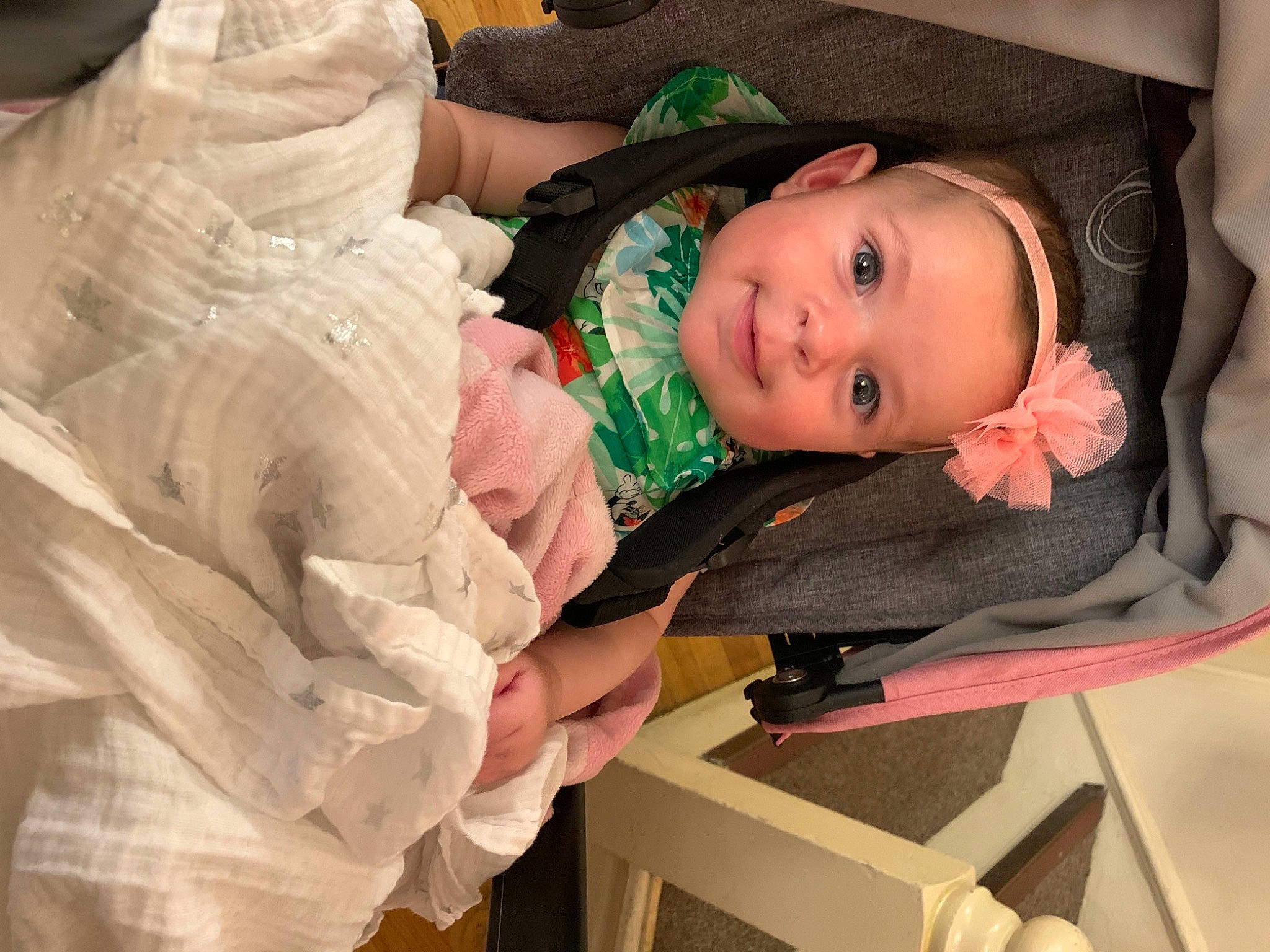 Emelia is registered to the contest to win money with this photo: baby, baby_carriage, baby_products, baby_toddler_clothing, cheek, child, comfort, dress, facial_expression, fun, happy, human_body, iris, person, pink, sitting, skin, sleeve, smile, toddler