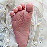 baby_foot, infant, closeup, skin, toes, soft, lace, fabric, pearls, rhinestones, texture, delicate, newborn, pink, small, cute, detail, foot, resting, background