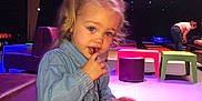 Mya participe au concours pour gagner de l'argent avec cette photo : toddler, child, drinking, glass, straw, bowling_alley, colorful, pigtails, blue_jacket, table, red_table, seating, indoor, person, casual_clothing, fun, recreation, leisure, young_child, activity