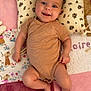 baby, infant, smiling, lying_down, onesie, pillow, quilt, patchwork, floral, cute, child, happy, indoors, skin, face, hand, foot, head, textile, comfort