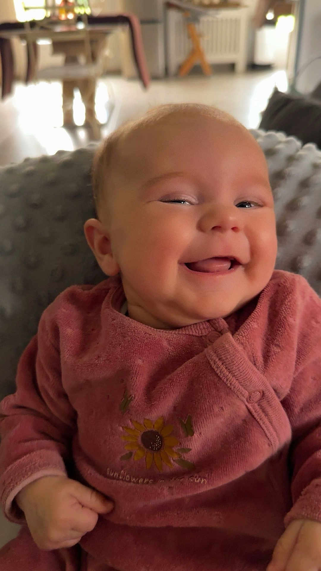 Victoire participe au concours pour gagner de l'argent avec cette photo : baby, smiling, infant, pink_clothing, sunflower_design, happy, cozy, blanket, indoor, portrait, cute, child, soft_light, closeup, face, cheeky, hands, texture, warm, comfortable