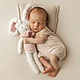 newborn, baby, sleeping, stuffed_animal, bunny, plush_toy, pillow, knitted, soft, peaceful, infant, cute, child, portrait, cuddling, lying_down, neutral_background, pastel_colors, cozy, adorable