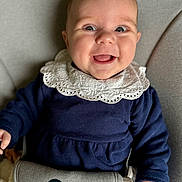 Victoire participe au concours pour gagner de l'argent avec cette photo : baby, child, smile, happy, face, clothing, lace_collar, seat, cushion, infant, person, portrait, cute, small_hand, indoors, apparel, expression, joy, closeup, sitting