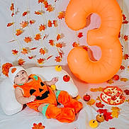 Mia Victoria joined the competition — help win amazing prizes! baby, child, infant, portrait, pumpkin_costume, orange_clothing, autumn, fall, halloween, giant_balloon, number_three, leaves, mini_pumpkins, cookies, festive, bed, pillow, indoor, decorations, smiling