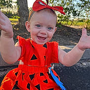 Rhyzelynne is registered to the contest to win money with this photo: toddler, child, smiling, orange_dress, headband, outdoor, nature, trees, sunlight, happy, baby, person, grass, playful, cute, portrait, sitting, arms_outstretched, daylight, young_child