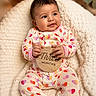 Layla joined the competition — help win amazing prizes! baby, infant, onesie, heart_pattern, wooden_sign, blanket, knitted, smiling, sitting, cute, portrait, indoors, soft_lighting, cozy, milestone, child, person, happy, holding, decor