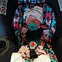 baby, car_seat, pacifier, hat, bow, infant, clothing, patterned, butterfly, seatbelt, socks, pink, purple, blue, black, white, cute, child, newborn, sitting
