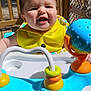 baby, child, smiling, yellow_clothing, baby_walker, toy, outdoor, wooden_deck, happy, face, infant, sunlight, playful, colorful, person, young_child, cute, cheerful, seat, daylight