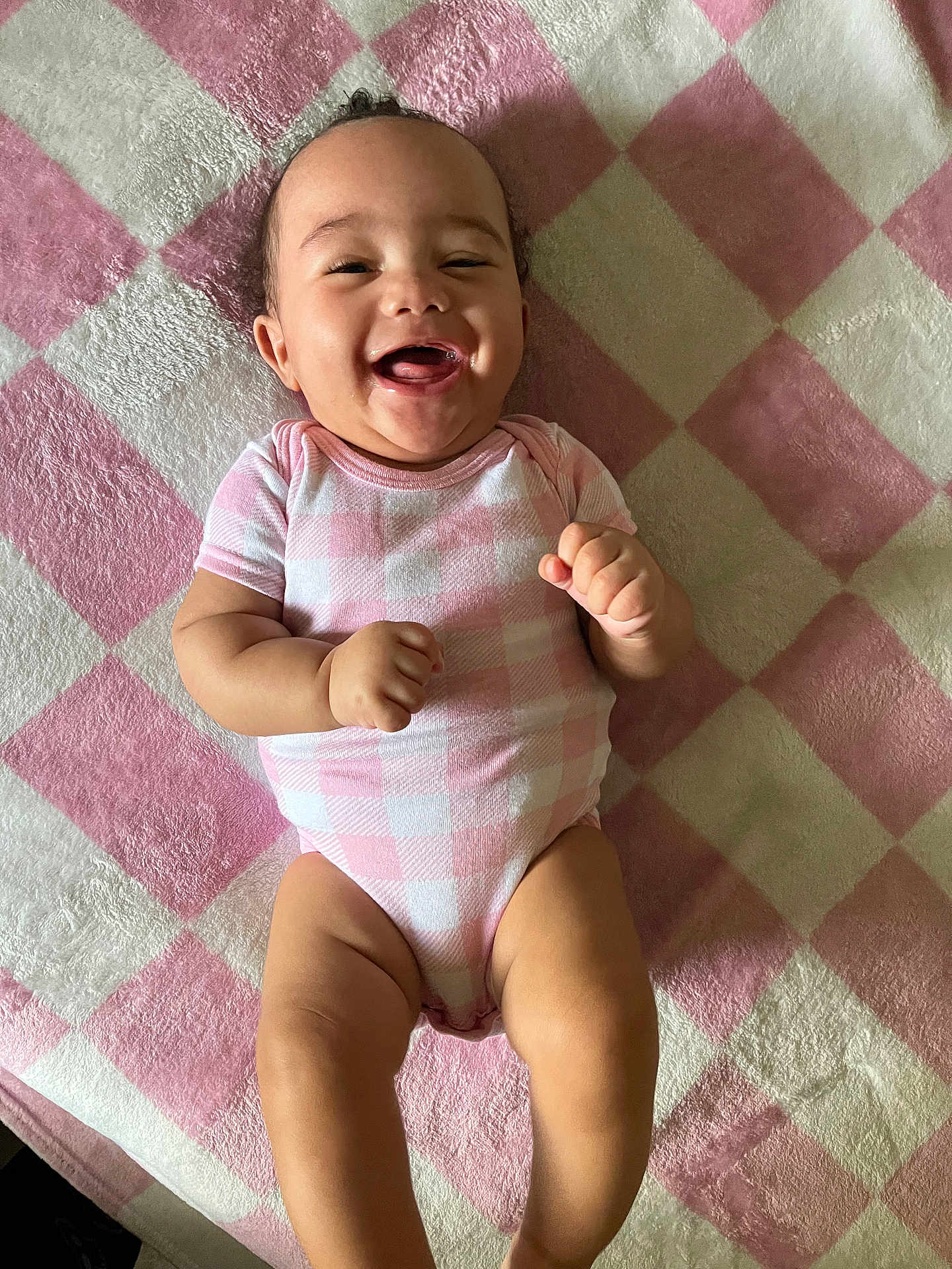 Kaiairi joined the competition — help win amazing prizes! baby, infant, smiling, happy, onesie, pink, white, checkered, blanket, lying_down, cute, chubby, fist, face, skin, child, portrait, indoors, toddler, young