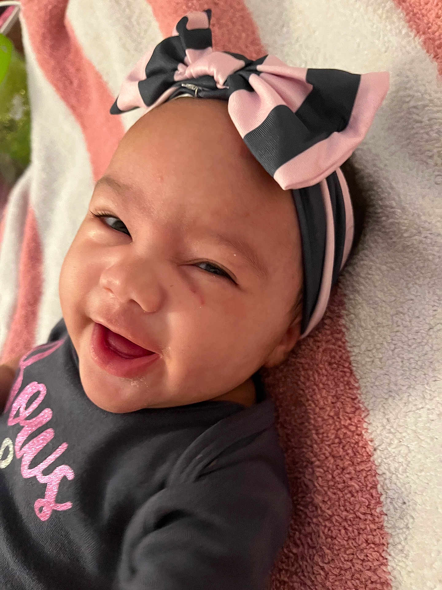 Kaiairi joined the competition — help win amazing prizes! baby, black, bow, child, closeup, clothing, cute, expression, face, happy, headband, infant, lying_down, person, pink, portrait, skin, smiling, towel, young