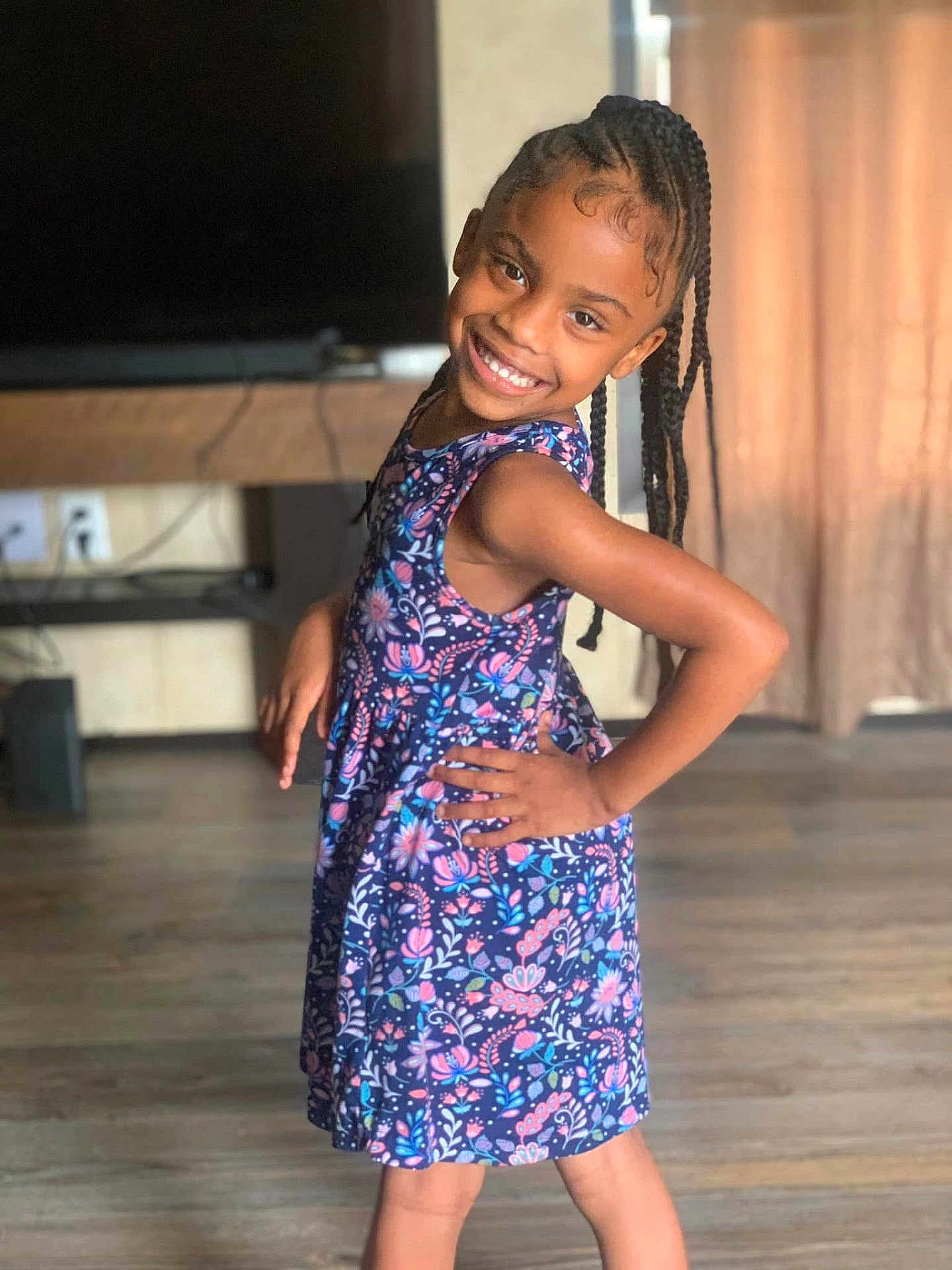 Nevaeh joined the competition — help win amazing prizes! child, girl, smile, braids, dress, floral_pattern, posing, indoor, wood_floor, curtains, happy, person, young, confident, fashion, hair, portrait, casual, standing, cute