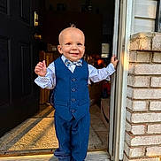 Roman joined the competition — help win amazing prizes! toddler, child, boy, smile, suit, bow_tie, doorway, doorframe, shoes, carpet, brick_wall, indoor, outdoor, sunlight, portrait, standing, happy, fashion, cute, home