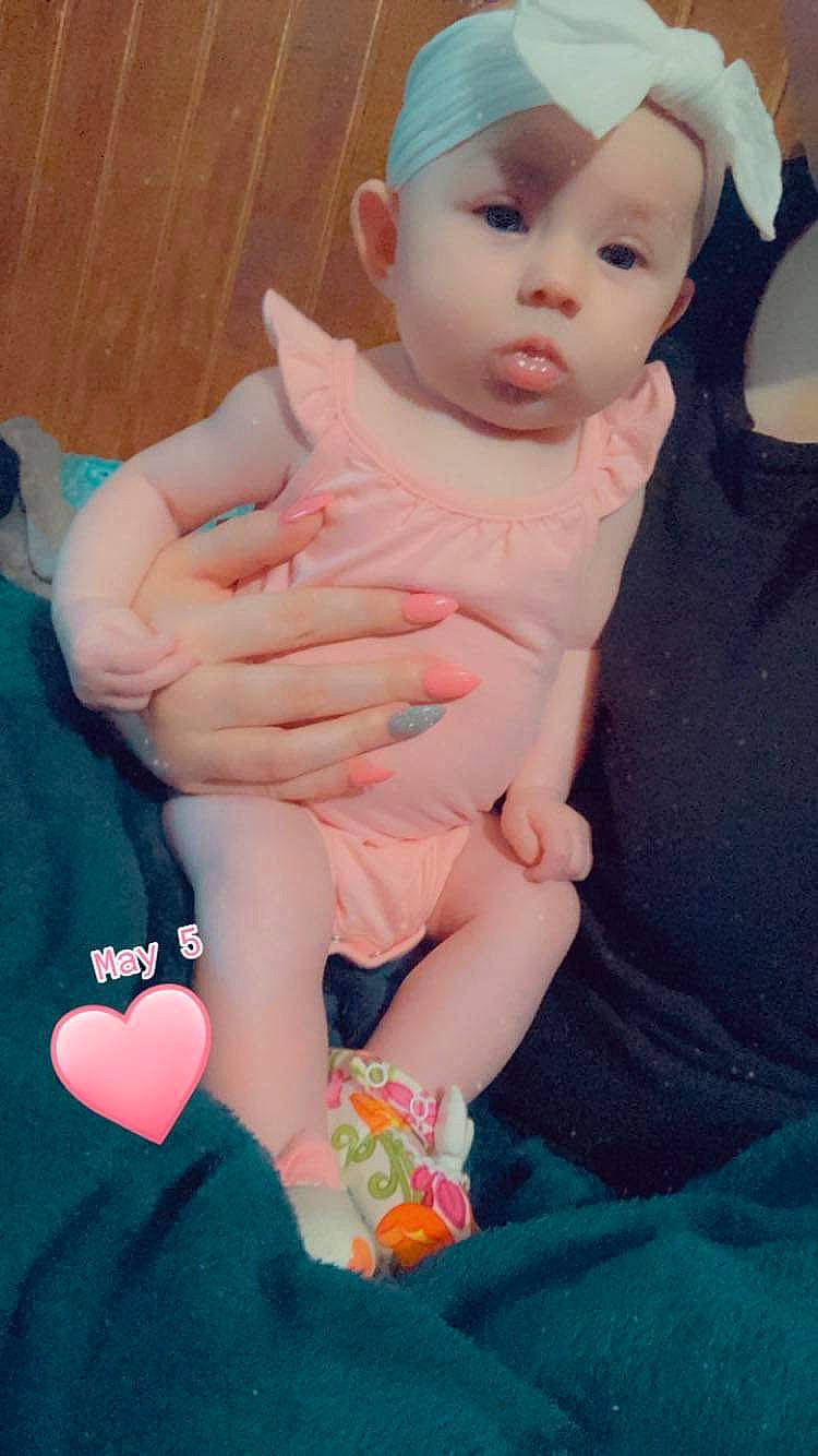 Finley is registered to the contest to win money with this photo: baby, baby_toddler_clothing, cap, child, dress, finger, hand, hat, headwear, human_body, human_leg, knee, leg, nail, person, pink, skin, sleeve, sock, thigh