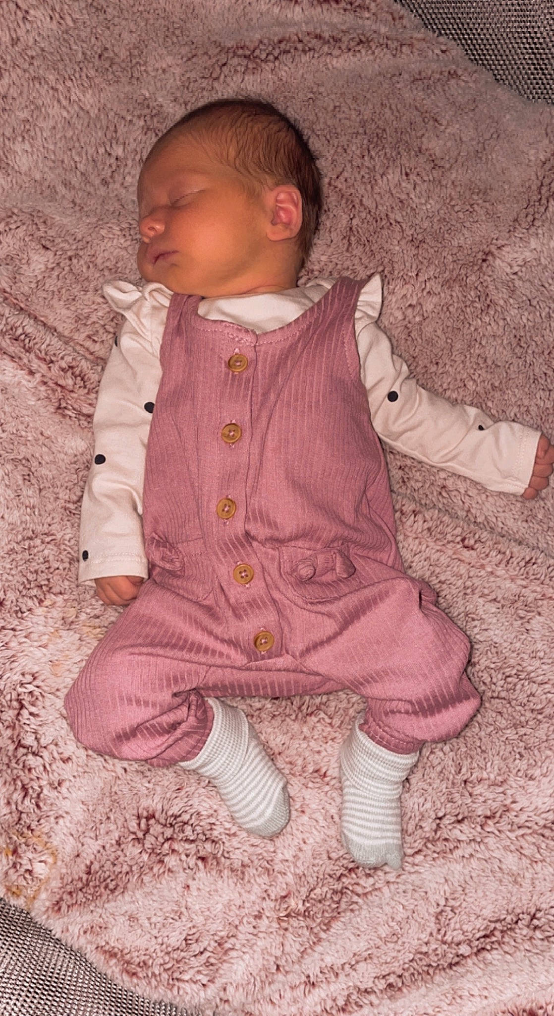 Remi is registered to the contest to win money with this photo: baby, baby_toddler_clothing, child, dress, face, fur, grass, head, jacket, magenta, pattern, people_in_nature, person, pink, sitting, sleeve, sock, toddler, tree, wood