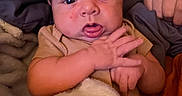 Kayson is registered to the contest to win money with this photo: baby, infant, face, hand, blanket, clothing, person, indoors, sleepwear, expression, newborn, skin, comfort, rest, portrait, cuddly, soft, young, cute, child
