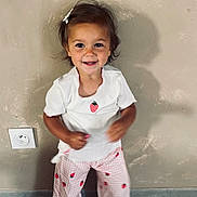 Lila participe au concours pour gagner de l'argent avec cette photo : toddler, child, smiling, white_shirt, strawberry, pink_pants, patterned_pants, indoor, wall, power_outlet, short_hair, hair_clip, happy, motion_blur, barefoot, cute, standing, light_shadow, casual_clothing, playful