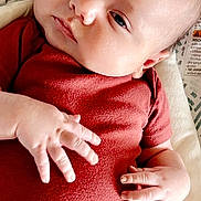 Michael joined the competition — help win amazing prizes! baby, infant, newborn, onesie, red_onesie, hands, face, eyes, lying_down, baby_seat, patterned_background, cheeks, closeup, portrait, soft_texture, candid, relaxed, small_hands, infant_clothing, skin