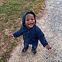 toddler, child, smiling, hoodie, jeans, outdoor, grass, gravel, path, footwear, happy, casual_clothing, person, young_child, nature, playful, cute, walking, daylight, expression