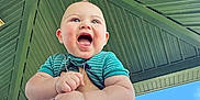 Marcelo is registered to the contest to win money with this photo: baby, child, smiling, happy, hands, holding, outdoor, sky, pavilion, green_roof, person, cute, expression, blue_sky, daylight, clothing, short_sleeves, infant, nature, fun