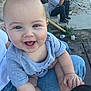 baby, smiling, blue_eyes, gray_shirt, person, man, phone, outdoor, stone_wall, concrete, steps, grass, jeans, hand_holding, happy, infant, casual, daylight, sitting, yard