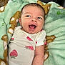 Emberlee is registered to the contest to win money with this photo: baby, infant, smiling, blanket, green_blanket, strawberry_pattern, onesie, happy, cute, portrait, child, indoor, soft_texture, cozy, toddler, face, skin, head, expression, lying_down