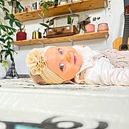 Abby participe au concours pour gagner de l'argent avec cette photo : baby, blue_eyes, books, child, curious, cute, decor, floor, flower, guitar, headband, home, indoor, plants, portrait, shelves, smile, soft_lighting, vintage_suitcase, white_clothing