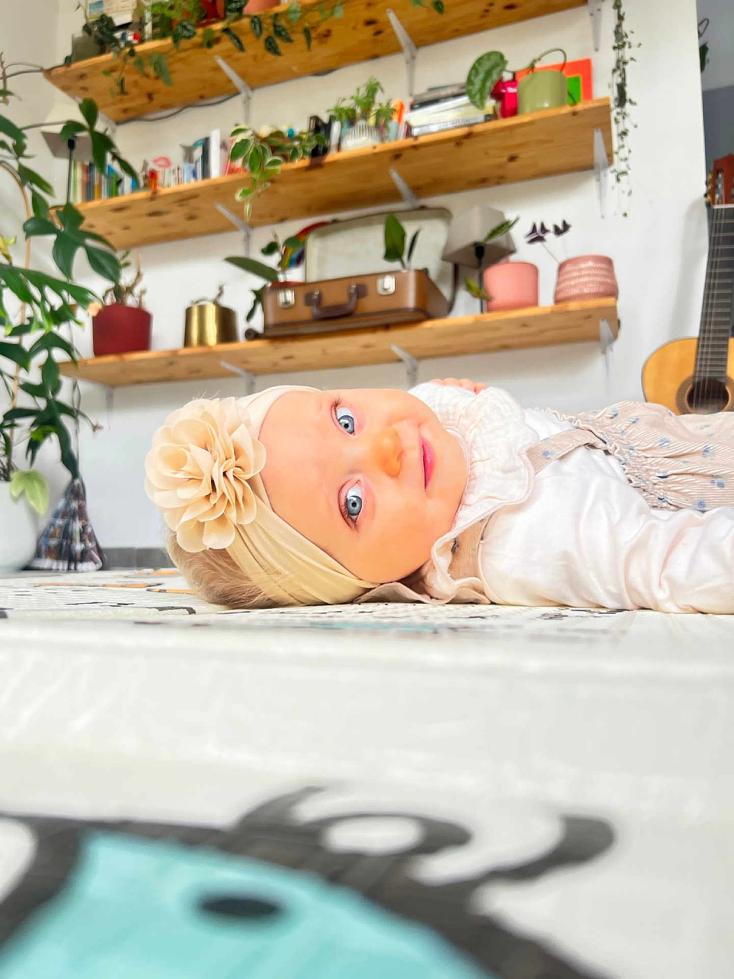 Abby participe au concours pour gagner de l'argent avec cette photo : baby, blue_eyes, books, child, curious, cute, decor, floor, flower, guitar, headband, home, indoor, plants, portrait, shelves, smile, soft_lighting, vintage_suitcase, white_clothing