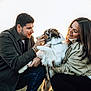 man, woman, dog, outdoor, sunset, grass, field, pet, happy, smiling, crouching, casual_clothing, nature, affection, leash, fur, daylight, portrait, interaction, love