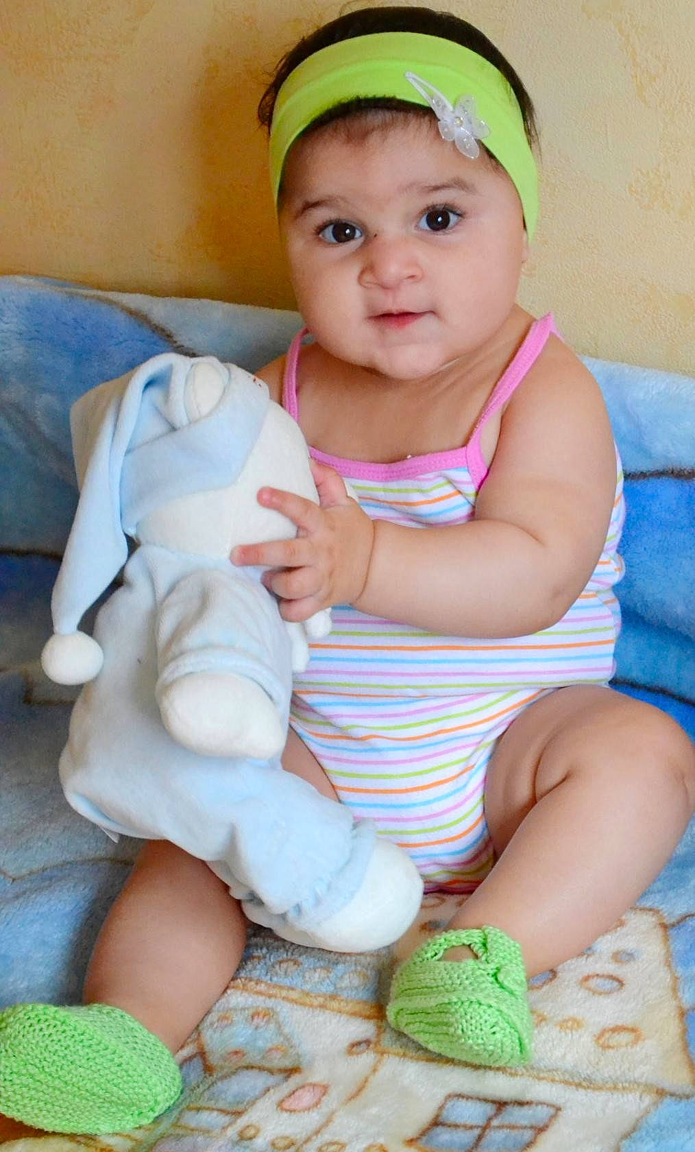 Milana participe au concours pour gagner de l'argent avec cette photo : abdomen, child, eye, finger, fun, girl, hair_accessory, hand, headgear, human_hair_color, infant, leg, person, play, product, sitting, skin, smile, textile, toddler