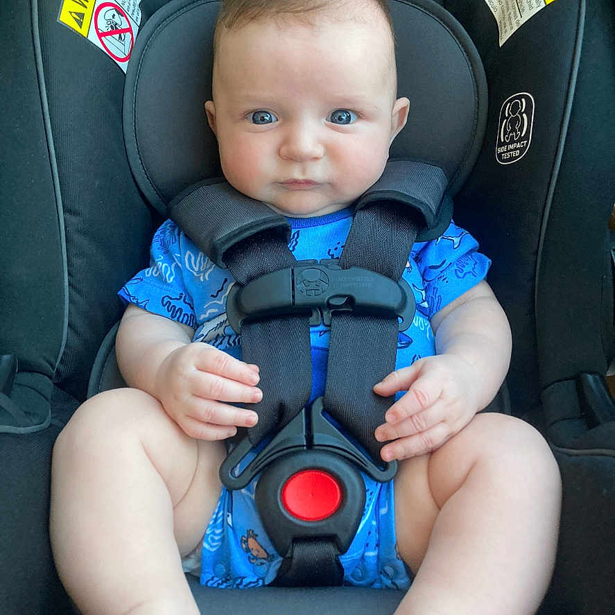 Jackson is registered to the contest to win money with this photo: baby, bodypart, car, car_interior, carseat, clothing, cushion, face, finger, hand, head, homedecor, lifejacket, person, photography, portrait, sitting, transportation, vehicle, vest