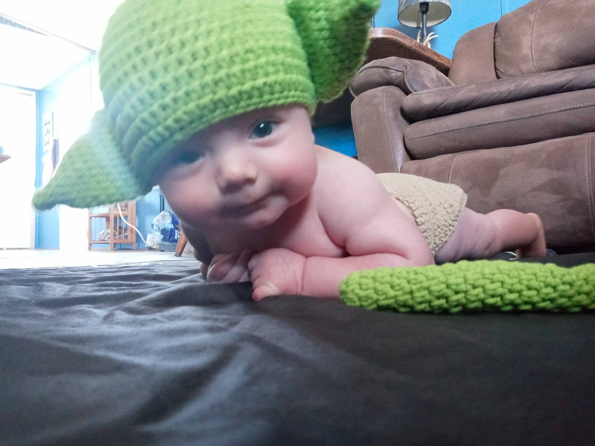 Keanu is registered to the contest to win money with this photo: baby, cap, child, comfort, couch, fashion_accessory, finger, flooring, fun, grass, headgear, headwear, knit_cap, linens, person, skin, textile, thumb, toddler, tummy_time