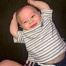 Grayson is registered to the contest to win money with this photo: baby, infant, child, smiling, portrait, couch, indoors, lying_down, raised_arms, striped_shirt, shorts, clothing, face, eyes, mouth, happy, relaxed, home, close_up, photography