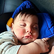 Magnus Grey is registered to the contest to win money with this photo: baby, infant, sleeping, closed_eyes, chubby_cheeks, face, head, hair, hand, arm, blue_cushion, clothing, car_seat, portrait, close_up, peaceful, rosy_cheeks, eyelashes, lips, indoor