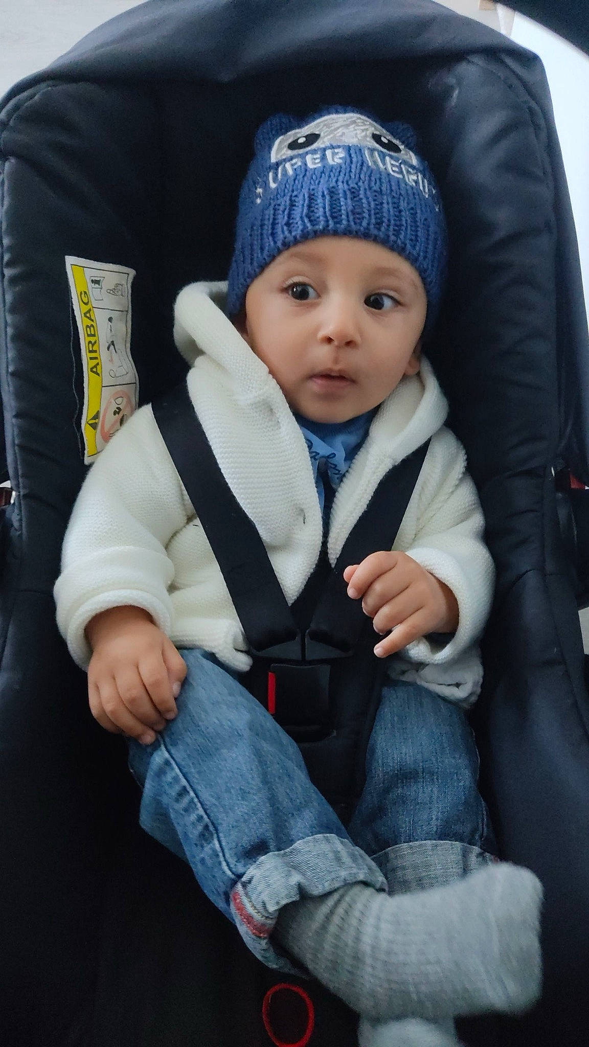 Eymen participe au concours pour gagner de l'argent avec cette photo : baby, baby_carriage, baby_products, baby_toddler_clothing, beanie, blue, cap, car_seat, clothing, comfort, denim, electric_blue, fashion_accessory, headgear, headwear, hood, knit_cap, person, sitting, sleeve