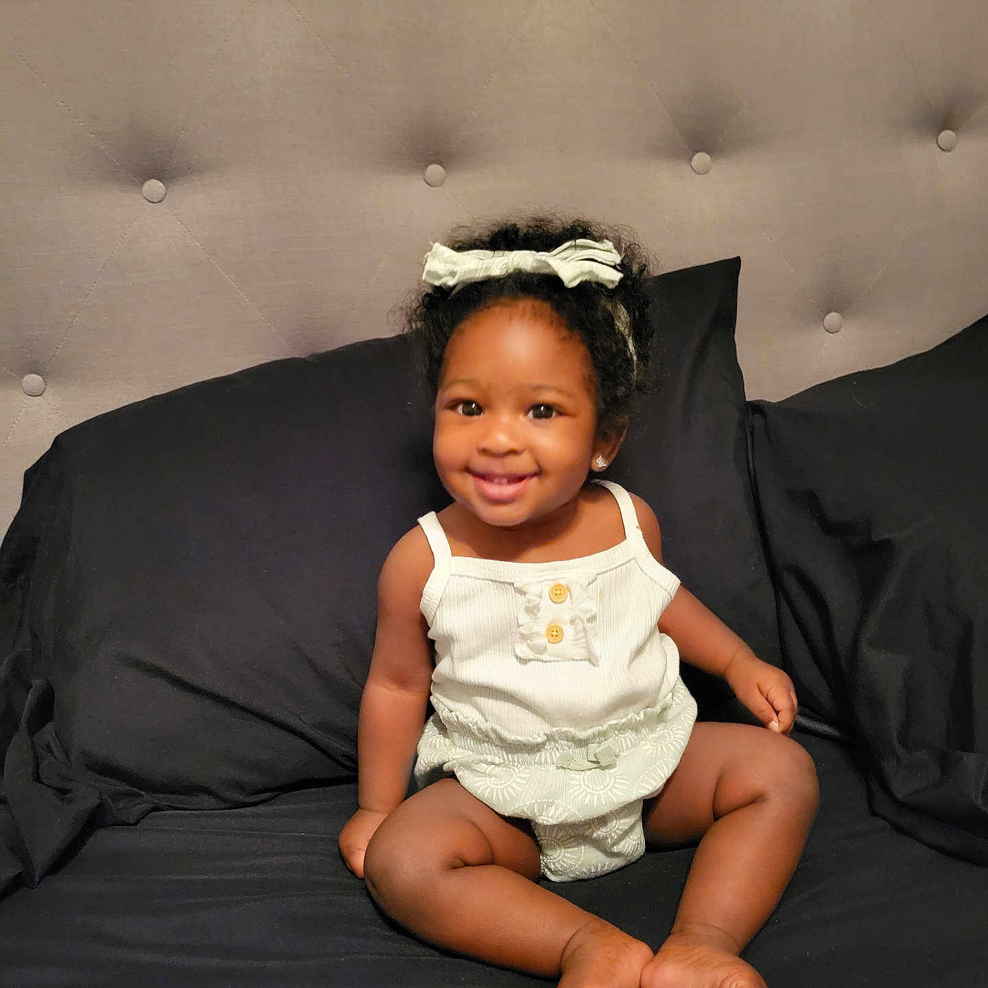 Nova is registered to the contest to win money with this photo: accessories, baby, bed, bedroom, clothing, couch, cushion, diaper, face, furniture, happy, head, homedecor, indoors, person, photography, portrait, room, sitting, smile