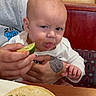 Bennett is registered to the contest to win money with this photo: baby, child, food, lime, taco, restaurant, table, hand, tattoo, face, expression, sour, sitting, clothing, person, plate, indoor, furniture, booth, meal