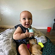 Bennett joined the competition — help win amazing prizes! baby, child, toy, plush_toy, pillow, elephant_pattern, floor, red_cup, wall, indoor, happy, smiling, sitting, clothing, head, face, hand, foot, colorful, curious