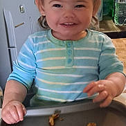 June is registered to the contest to win money with this photo: toddler, child, smile, high_chair, tray, cereal, pasta, striped_shirt, blue_shirt, hands, messy_eating, hair, eyes, teeth, kitchen, water_bottle, bottle, happy, portrait, meal