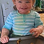 toddler, child, smile, high_chair, tray, cereal, pasta, striped_shirt, blue_shirt, hands, messy_eating, hair, eyes, teeth, kitchen, water_bottle, bottle, happy, portrait, meal