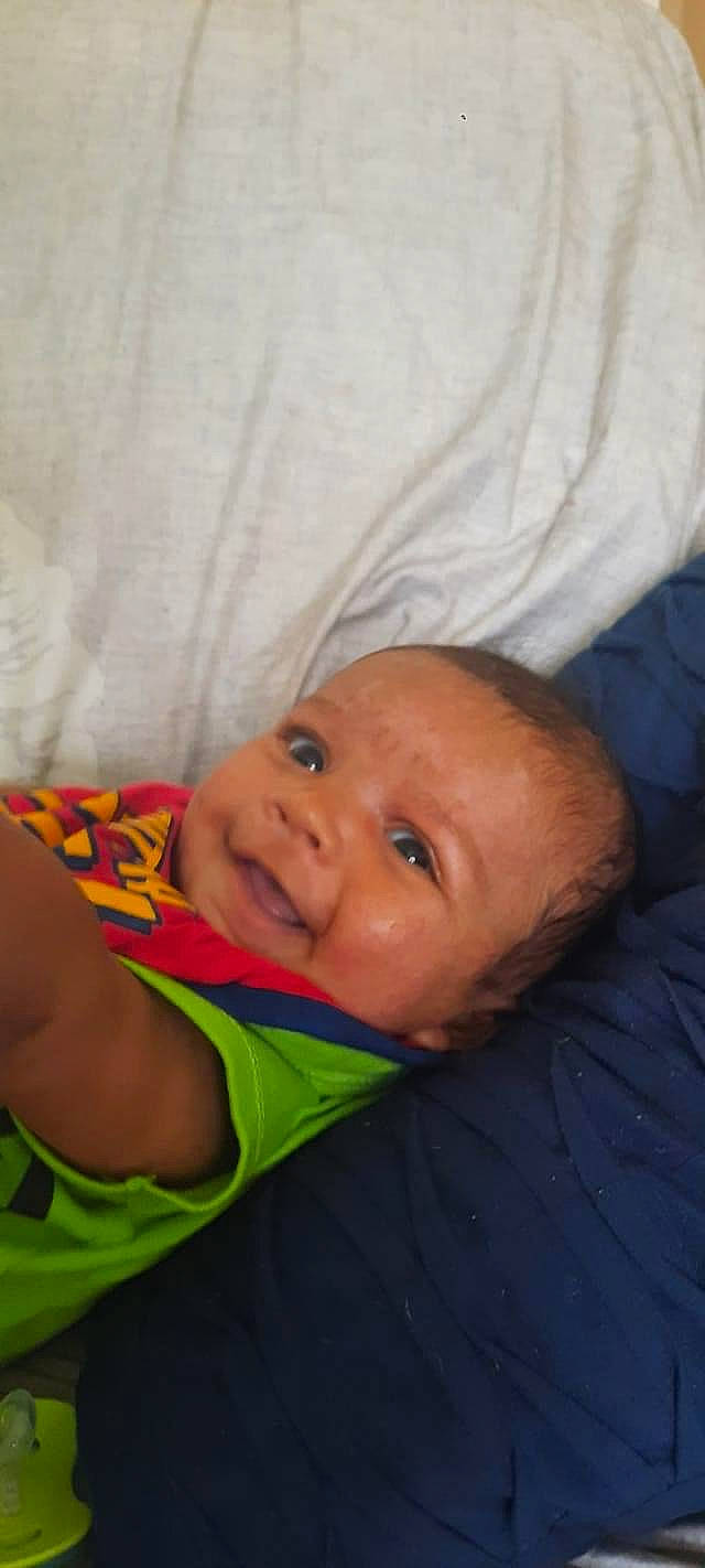 Robert is registered to the contest to win money with this photo: baby, baby_products, baby_toddler_clothing, cheek, child, comfort, eyebrow, finger, fun, grass, happy, headgear, leisure, linens, nose, person, room, sitting, smile, toddler