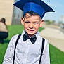 Erick is registered to the contest to win money with this photo: bow_tie, boy, candid, celebration, ceremony, child, ears, face, formal, graduation_cap, grass, hair, happy, outdoors, portrait, smile, sunlight, suspenders, white_shirt, young