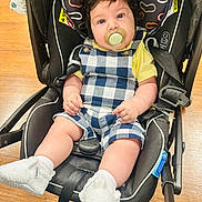 Elliam joined the competition — help win amazing prizes! baby, infant, pacifier, car_seat, stroller, plaid_overalls, yellow_shirt, baby_booties, seat_belt, safety_label, wooden_floor, curly_hair, blue_eyes, chubby_cheeks, hands, legs, close_up, indoor, portrait, parenting