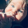 baby, infant, close_up, blue_eyes, hand, fingers, mouth, face, portrait, sunlight, shadow, cheek, hair, car_seat, skin, eyelashes, teething, adorable, palm, candid