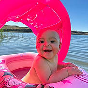 Rosalie joined the competition — help win amazing prizes! baby, child, inflatable, pool, water, pink, canopy, hand, smiling, sunlight, outdoor, summer, lake, floating, happy, skin, person, blue_sky, nature, fun