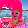 baby, child, inflatable, pool, water, pink, canopy, hand, smiling, sunlight, outdoor, summer, lake, floating, happy, skin, person, blue_sky, nature, fun