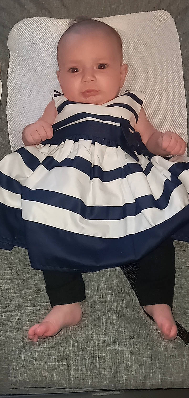 Annalise is registered to the contest to win money with this photo: baby, baby_products, baby_toddler_clothing, black, gesture, human_leg, knee, neck, outerwear, pattern, person, photograph, pollinator, sleeve, street_fashion, style, t_shirt, thigh, thumb, toddler